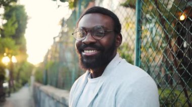 Kameraya bakan Afrikalı genç Amerikalı adamla yüzleş. Mutlu gülümse. Doğaya bak, teknolojiye bak.