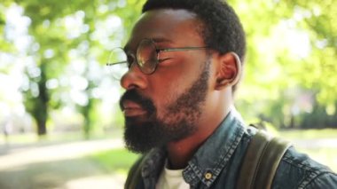 Ciddi, Afro-Amerikalı, gözlüklü, kameraya bakan, yakından bakan, doğa teknolojisi yüzlü, sıradan, yakışıklı, siyah, açık hava sakallı, neşeli, kentsel, ağır çekim.