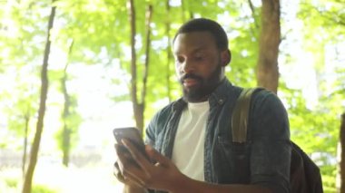 Ciddi afro-amerikan genç çekici adam caddede duruyor üzgün günbatımı güneş ışığı günbatımı bilgisayarı internet teknolojisi iş adamları siyah şehir gezgini