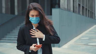 Beyaz kadın ofis müdürü. Molada akıllı telefon kullanıyor. Göğüs basıncı ve dışarıda öksürük ağrısı çekiyor. Coronavirus belirtileri. Sağlık Hizmetleri.