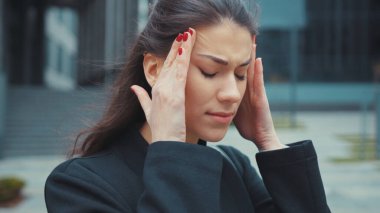 Hasta yorgun, çok çalışan beyaz bir kadın şakaklarına dokunduğu için şiddetli baş ağrısı çekiyor. Yorgun insanlar. İş adamı. Sağlık hizmeti kavramı.