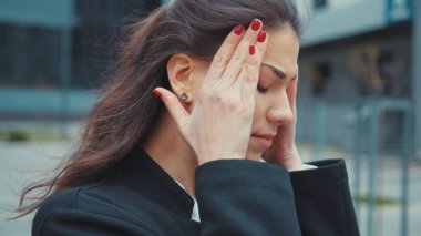 Hasta yorgun, çok çalışan beyaz bir kadın şakaklarına dokunduğu için şiddetli baş ağrısı çekiyor. Yorgun insanlar. İş adamı. Sağlık hizmeti kavramı.