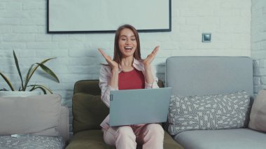 Neşeli genç bayan işçiler iş başarısını kutlamak için dizüstü bilgisayarlarından harika haberler öğreniyorlar..