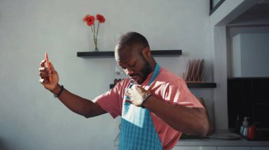 Video görüşmesi için akıllı telefonu kullanan, arkadaşlarıyla internetten sohbet eden, kendi mutfağında kalan yakışıklı bir zenci. Bağlantı. İletişim kuran insanlar.