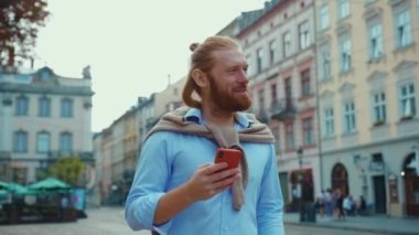 Neşeli kızıl sakallı milenyum sakallı adam akıllı telefon aleti kullanıyor. Dışarıda tek başına yürüyen eşiyle mesajlaşıyor. Kafkas halkı..