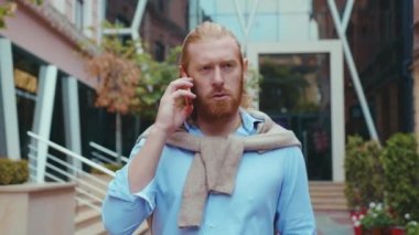 Yakışıklı kızıl saçlı milenyum girişimcisi dışarıda akıllı telefon konuşmaları yapan bir iş adamı. Sıradan akıllı iş adamı. Çekici kızıl..