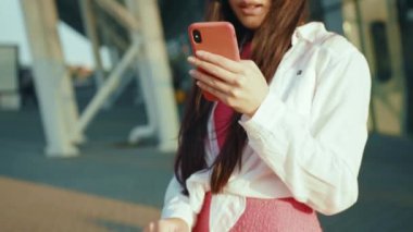 Cep telefonu iletişimi kullanarak gülümseyen çekici Çinli kadın havaalanının dışında gezinen navigasyon haritasında yerleri arıyor. Güzel Asyalı kız. Gezgin. İş gezisi.
