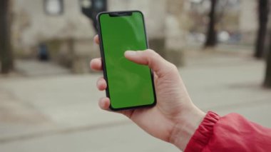 Los Angeles, Kaliforniya 15 03 2019 EDITORIAL: Yeşil ekran dikey arka plan parkı şehir dijital ekran akıllı telefon teknolojisi güneş ışığı kullanarak el ele tutuşan ve telefona dokunan adam