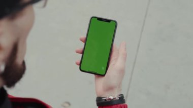 Los Angeles, Kaliforniya 15 03: 2019 Arka plan EDITORIAL: Yakın çekim eller yeşil ekran dikey arka plan kaldırımı dijital ekran akıllı telefon adam ayakta ve telefona dokunuyor