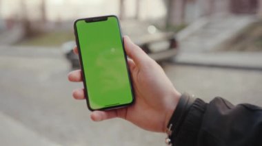 Los Angeles, California 15 03 2019 EDITORIAL: Eller dursun ve yeşil ekran dikey arka plan yol arabasıyla telefona dokunsun dijital ekran akıllı telefon teknolojisi güneş ışığı