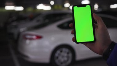 Los Angeles, California 15 03 03 2019 EDITORIAL: mavi ceket ve saat giyen genç beyaz adamın eli. Adam modern cihaz kullanıyor. Park yeri, yeraltı garajı. Kapalı, ekran, düzenlenebilir, boş