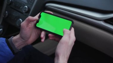 Los Angeles, California 15 03 03 2019 EDITORIAL: akıllı telefonu elinde tutan genç adam, mobil oyun oynuyor. Adam alet kullanıyor. Çağdaş. Yolcu koltuğu. Arabaların içi. Modern teknoloji, yeşil