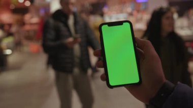 Los Angeles, Kaliforniya 15 03 03 2019 EDITORIAL: Yeşil ekranlı cep telefonu tutan genç kişinin sağ kolu. Süpermarket. Aşık çiftlerin siluetleri. Bulanık görüş. İçeride. Gadget, aygıt.