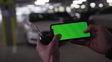 Los Angeles, California 15 03 2019 EDITORIAL: akıllı telefon ve araba anahtarı tutan erkek eller. Yeni aracın arka planında akıllı telefon kullanan genç biri. Bulanık görüş. İçeride. Modern teknoloji. Şehir