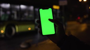 Los Angeles, California 1503 2019 EDITORIAL: doğru troleybüsü arayan genç adam. Otobüs durağı. Yüzü olmadan. Erkek eli ekranda. Gadget. Bulanık ışıklar. Toplu taşıma. Parmak. İyi akşamlar.