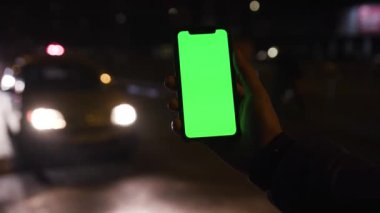 Los Angeles, California 15 03 03 2019 EDITORIAL: Arkaplanda bulanık otomobil manzarası olan akıllı telefonlu genç beyaz adamın eli. Akşam vakti trafik vardı. Yağmurlu bir hava. Gadget, aygıt.