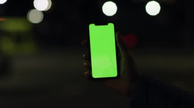 Los Angeles, California 15 03 2019 EDITORIAL: Farkına varılamayan el ele tutuşmaya ve gece lambaları üzerindeki akıllı telefonu kullanmaya odaklanmak bulanık bir arka plan. Krom anahtar, tıkırtı.
