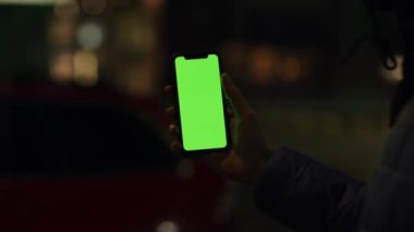 Los Angeles, California 15 03 2019 EDITORIAL: Tanımlanamayan bir kızın eli ekranda arka plandaki akıllı telefonu işaret ediyor.