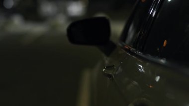 Adam gece uzaktan kumandalı anahtarla arabanın kapısını açıyor. Park halindeki aracın uzaktan kumandalı alarm sisteminde erkek el baskısı. Otomotiv alarmını kapatıyorum. Arabanın ışıklarını kapat.