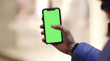Los Angeles, California 15 03 2019 EDITORIAL: Adam elinde tutuyor ve işaret parmağıyla dokunmatik ekranla portre modunda beyaz ekranda izole edilmiş yeşil ekran. Yerleştirme için krom anahtar ekranı
