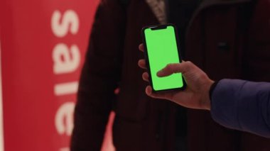 Los Angeles, California 15 03 03 2019 EDITORIAL: Bulanık tabela arka planında krom renkli akıllı telefon kullanarak erkek eli görüntüsünü kapatın. Alışveriş zamanı sohbet çevrimiçi uygulama yeşil ekran alışveriş merkezi