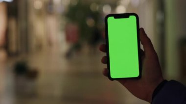 Los Angeles, California 15 03 03 2019 EDITORIAL: Yürüyen insanlar üzerinde sokakta boş yeşil ekranlı akıllı telefon kullanan bir erkek. Chromakey, tıklama görüntüsü, değiştirme kanat çırpma, tıklatma