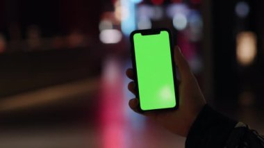 Los Angeles, Kaliforniya 15 03 03 2019 EDITORIAL: Erkek el alacakaranlıkta dikey olarak akıllı telefon tutar, sihirli saat gecesi. Yeşil Ekran Krom Anahtarı. Kapatın. İzleme hareketi. Dikey. Teknoloji