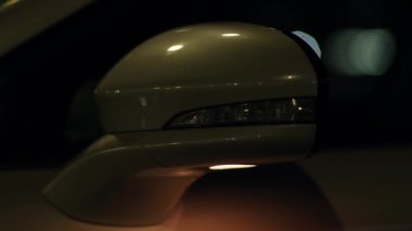 Modern yeşil lüks araba farları, düşük ışıkla yanıp sönüyor ve geceleri sinyal veriyor. Lüks model, araçlar ve ulaşım konsepti. Trafik ışıkları, manzarayı kapatın.