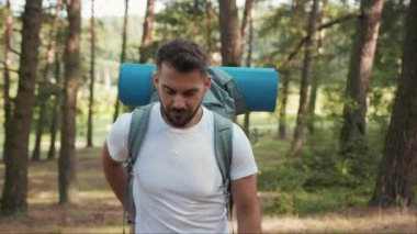 Ormanda sakallı ve sırt çantalı gülümseyen bir adam ekranda GPS 'i aramak için telefon kullanıyor. Uygulama turizmi yürüyüşü, kayıp güneş iletişimi telefonu, yavaş çekim.