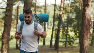 Ormanda yürürken sakallı ve sırt çantalı mutlu bir adam gülümsüyor. Gülümsüyor, GPS 'e başvuruyor, turist gezintisine çıkıyor. Güneş iletişimini kaybediyor.