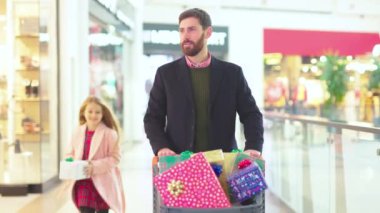 Kızıyla birlikte portre babası Noel hediyesi kutuları alışveriş merkezindeki alışveriş arabasında baba gülümsemesi çocuk ticareti müşteriler kış yürüyüşünü seviyorlar.