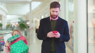 NEW YORK - 5 Nisan 2019: Komik bir baba kızıyla telefon yürüyüşü yaptı büyük bir Noel hediyesi kutusunu yere düştü baba çocuk mağazası müşterisi kış Xmas 'ını seviyor