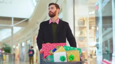 Hüzünlü, genç ve çekici bir adam Noel hediyeleriyle yürüyor. Kutularla geziyor. Etrafa bakıyor ve yeni yıl resmi alıyor.