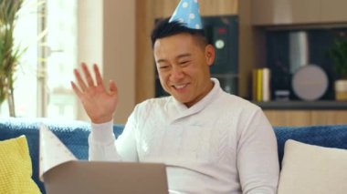 Asyalı mutlu adam dizüstü bilgisayarlı video kaset aracılığıyla anneyle iletişim kuruyor tatilin tadını uzaktan kutluyor. Alarm! Karantina, sosyal tecrit, evde kalmak..