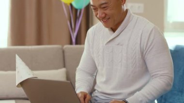 Doğum günü partisi. Heyecanlı Asyalı Asyalı adam, karantinada kendi kendini izole ederek eski dostuna sevinç diliyor. Sosyal mesafeler, online ilişkiler, uzaktan kutlama. Kalıyorum.