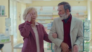 Eczanede yürüyen yaşlı bir çift. Başım ağrıyor. Konuşma farmasötik müvekkili. Ticari sağlık hizmetleri alıcısı üniforması. Yavaş çekim