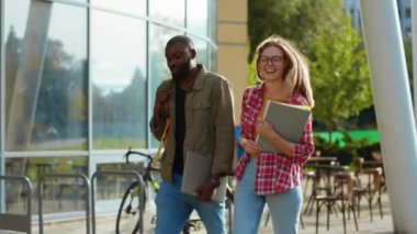 Çok ırklı, genç bir çift, dışarı çıkıp sohbet ediyor, fikirlerini paylaşıyor, gülümsüyor ve birlikte eğleniyorlar. Romantik erkek ve kadın. En iyi arkadaşlar.