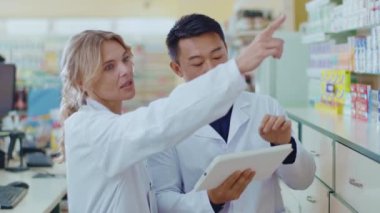 Çekici kadın ve Asyalı erkek eczanede iş birliği yapıyor. Tablet bilgisayar kullanıyorlar. Kadın eczacı, erkek meslektaşıyla hapları öğreniyor. Yavaş çekim