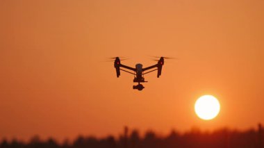 Günbatımında tarlaların üzerinde uçan modern akıllı helikopter. Çiftlik arazisindeki profesyonel dron izleme taraması. Teknoloji yenilikleri.