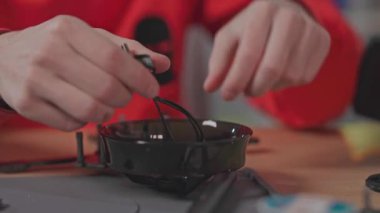 Kafkasyalı erkek mühendisin insansız hava aracı inşa edişine yakından bakın. Quadcopter üzerinde çalışırken profesyonel çekim. Hava aracı. El işi. Robotlar. Mühendislik laboratuvarı. Bilimsel bir kavram. İçeride. İHA tipi. Modellik. Gündüz.