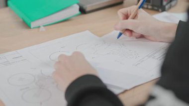 Öğrencilerin insansız hava aracı projeksiyonu çekimleri, işte kuadkopter prototipi çizimleri. İHA 'yı ilk gören kişi. Kaliteli iş. Modern teknoloji, alet. Hava aracı. El işi. Robotlar. Mühendislik laboratuvarı. Bilimsel bir kavram. İçeride. Özellikler, araç.