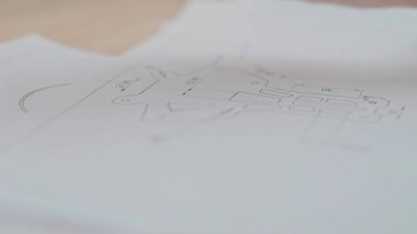 Erkek mühendisin kuadkopter üzerinde çalıştığı görüntüler, masasında insansız hava aracı çizimleri. Veri. 3 boyutlu nesne, illüstrasyon konsepti. Araştırma ekipmanları. Ucuz bir alet. İçeride. Kaliteli iş. Modern teknoloji, alet. Hava aracı. Robot bilimi. Model.