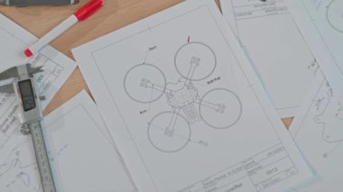 Çeşitli mühendislik tasarım taslakları ve araçları bir çalışma masasında titizlikle düzenlenmiş bir illüstrasyon