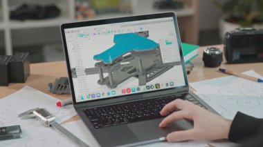 Yenilikçi bir mühendislik çalışma alanında detaylı bir üç boyutlu model titizlikle dizüstü bilgisayarda yaratılıyor.