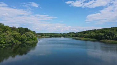 Sakin Orman Gölü 'nün muhteşem drone görüntüsü. Bulutlar suya yansıyor. Güzel doğa. Kapatın. Yavaş çekim