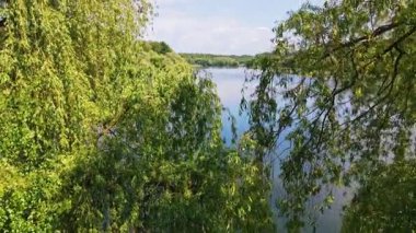 Mavi sakin orman gölünün hava aracı görüntüsü. Bulutlar suya yansıyor. Doğa. Kapatın. Yavaş çekim