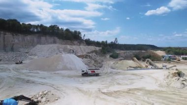 Taş ocağının endüstriyel makinelerle görüntüsü. Araç dışarıda çalışıyor. İnşaat malzemelerinin çıkarılması. Kum, taş, mineral. Taşıyıcı, hareket ediyor. Doğal materyal kavramı