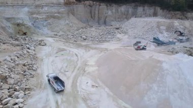 Hareket eden makinelerin görüntüleri. Kumu yüklemek için gelen büyük çöp kamyonunun üst görüntüsü. İHA saldırısı. Açık çukur. Bakış açısı. Sanayi manzarası