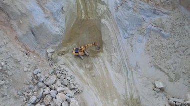 Kum ocağında çalışan sarı sürüngen kazıcısının drone görüntüleri. Doğal kaynaklar. Gündüz vakti. Açık çukur görüntüsü. Hava görüntüsü. Madencilik endüstrisi, açık hava