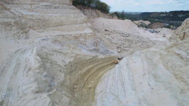 Kum ocağında çalışan kazıcı ve taş ocağı toplayıcısı. Endüstriyel arazinin insansız hava aracı görüntüleri. İnşaat endüstrisi için kum çıkarmak. Çukuru aç